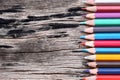 Closeup Color pencils concatenation on old wooden background. Royalty Free Stock Photo