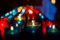 Closeup of colorful candles burning in the tunnel of Covadonga, Cangas de Onis, Asturias, Spain. Spirituality Royalty Free Stock Photo