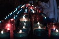 Closeup of colorful candles burning in the tunnel of Covadonga, Cangas de Onis, Asturias, Spain. Spirituality Royalty Free Stock Photo