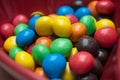 Colorful chocolate candies in a red bowl in shaped he