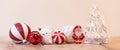 Closeup of colorful Christmas ornament balls with a small wooden Santa Claus figurine on the table Royalty Free Stock Photo