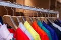 Closeup colorful male, female clothes in boutique hanging on hangers, clothing rack on metal stand. Concept opening