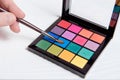 Closeup colorful palette for makeup with hand holding brush Royalty Free Stock Photo