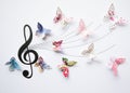 Closeup of colorful paper cut out butterflies eminating from an artistic musical staff