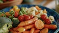 A closeup of a colorful plate showcases a variety of cooked vegetables representing the importance of a plantbased diet