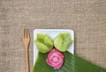 Closeup colorful Thai layer cake in flower shape on fresh green banana leaf