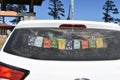 Closeup of colorful Tibetan Buddhist prayer flags hanging at the rear window of a car