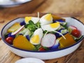 Closeup of colourful fresh organic healthy lettuce leaf vegetables and cabbage served with hen egg in  white metal bowl and home Royalty Free Stock Photo