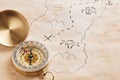 Closeup of compass over stained yellowed paper sheet with part of hand drawn treasure map Royalty Free Stock Photo