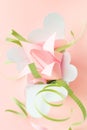 Closeup composition of pink Origami paper tulip with green decorations in white box-heart on pink background