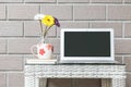 Closeup computer on blurred wood weave table and brown brick wall texture background , beautiful work place interior of house Royalty Free Stock Photo