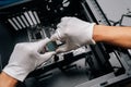 Closeup of computer technician wearing protective gloves positioning microprocessor onto electronic circuit board Royalty Free Stock Photo