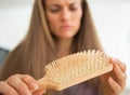 Closeup on concerned woman looking on hair comb