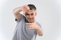 Closeup of confident happy man framing photograph white background.