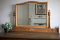 Closeup of a console wooden mirror with a reflection of a female painting in it