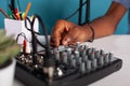 Closeup of content creator hand adjusting master volume fader on mixer console on desk