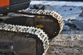 Closeup Continuous tracks or Tracked wheel of excavator or backhoe on the soil floor