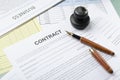 Closeup of contract documents, business newpaper, pen and stamp on the desk Royalty Free Stock Photo