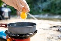 Closeup,Cook hands crack an egg on a pan,asian young man is pouring chicken egg into a hot frying pan to fry them as fried eggs Royalty Free Stock Photo