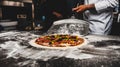 Closeup of a cook taking a whole raw pizza with a peel in the kitchen