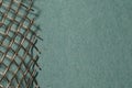 Closeup of a copper mesh on a green craft paper background with space for your text