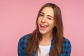 Closeup of coquettish happy girl in checkered shirt smiling and winking playfully, flirting to camera