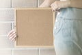 Closeup cork board in hand of woman beside the body