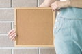 Closeup cork board in hand of woman beside the body