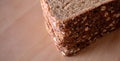 A closeup corner slices of fresh baked whole wheat multi grain bread on cutting board