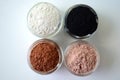 A closeup of cosmetic clays for detox face masks - French green clay, kaolin, pink clay, red clay and powdered activated charcoal Royalty Free Stock Photo