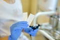 Closeup cosmetologist hands inserting needle into microblading device.