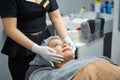 Closeup cosmetologists prepare customer's face before making facial massage with organic face scrub Royalty Free Stock Photo