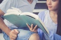 Closeup couple asian handsome man and beautiful woman reading book and glad at home Royalty Free Stock Photo