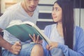 Closeup couple asian handsome man and beautiful woman reading book and glad at home Royalty Free Stock Photo