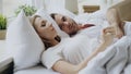 Closeup of couple with relationship problems having emotional conversation while lying in bed at home