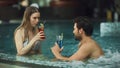 Young couple relaxing at whirlpool indoor. Attractive couple drinking cocktails Royalty Free Stock Photo