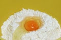 Cracked egg on raw flour in a yellow mixing bowl Royalty Free Stock Photo