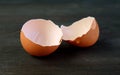 Closeup of cracked eggshells isolated on black wooden table Royalty Free Stock Photo