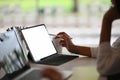 Closeup creative female holding stylus pen and pointing on screen of digital tablet.