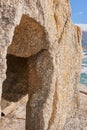 Closeup of a crevice or gully formed by the erosion of sea water. Large boulder or sandstone on a beach with the ocean