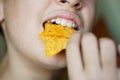 Crop anonymous girl biting yummy crunchy Mexican tortilla chips