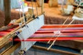 Closeup and crop colorful yarns with ancient wooden weaving machine on blurred background