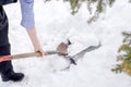 Closeup hand hold and using shovel scoop and cleared heap snow on floor