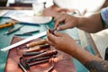 Closeup and crop hands of leather craftsman is working hard to sew a leather product for a customer