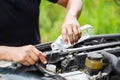 Closeup and crop image of hand of human checking car engine and filling water to the car radiator Royalty Free Stock Photo