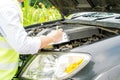 Closeup and crop Insurance agent writing on clipboard while examining car after accident claim being assessed and processed