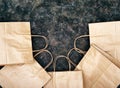 Closeup crop view of flat paper shopping bags on a dark grunge background. Flat lay, top view, copy space.