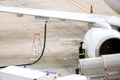 Closeup white airplane parked and refueling on ground in the airport with ground staff fixing Royalty Free Stock Photo