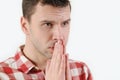 Closeup croped portrait young man praying hands clasped hoping for best asking for forgiveness or miracle on white background Royalty Free Stock Photo