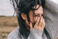 Closeup cropped portrait of happy and funny brunette woman smiling and laughing with hand on mouth, against nature meadow Royalty Free Stock Photo